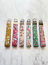 Liberty print key fob, brightly coloured selction of fabric strap, to ahnd on the write and act as a key ring, metal clasp and key ring attached for using with keys or security passes.